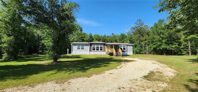 49266 Woodhaven Rd, Tickfaw, LA 70466 - view of front facade with driveway, a front lawn, and a forest view