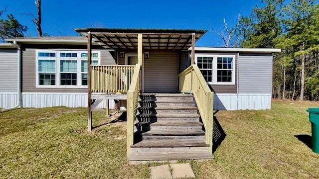 49266 Woodhaven Rd, Tickfaw, LA 70466 - back of property with a wooden deck, stairs, and a lawn