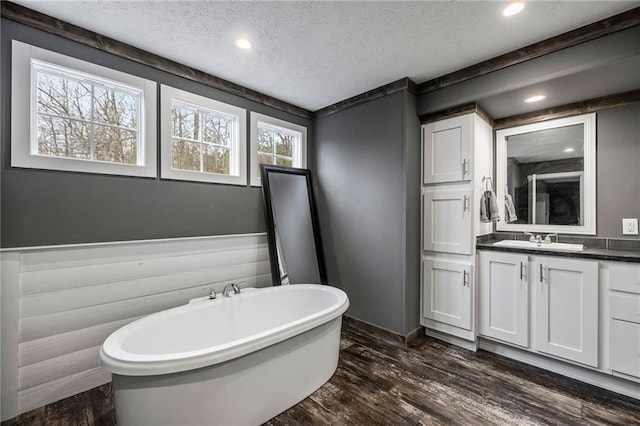 49266 Woodhaven Rd, Tickfaw, LA 70466 - bathroom with a soaking tub, a textured ceiling, wood finished floors, and vanity