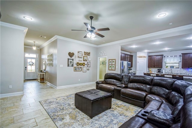 living room featuring crown molding, sink, and ceiling fan