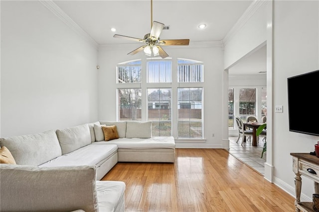 living room featuring ornamental molding, light hardwood / wood-style floors, and ceiling fan