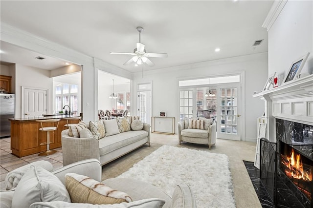 living room featuring crown molding, a fireplace, and ceiling fan