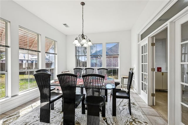 dining area featuring an inviting chandelier, light tile patterned floors, and french doors