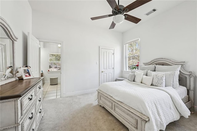 carpeted bedroom with ceiling fan, ensuite bathroom, and a closet