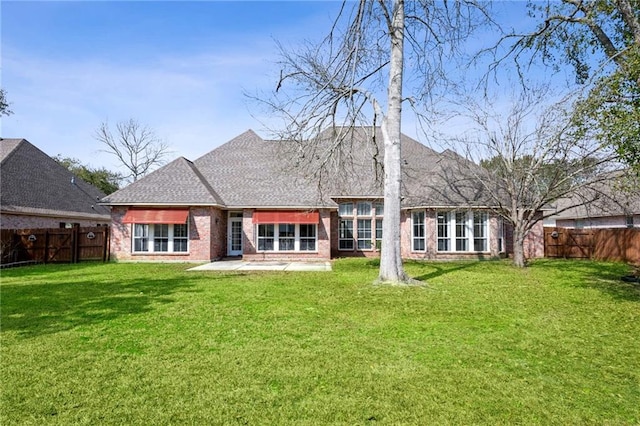 rear view of property featuring a lawn and a patio