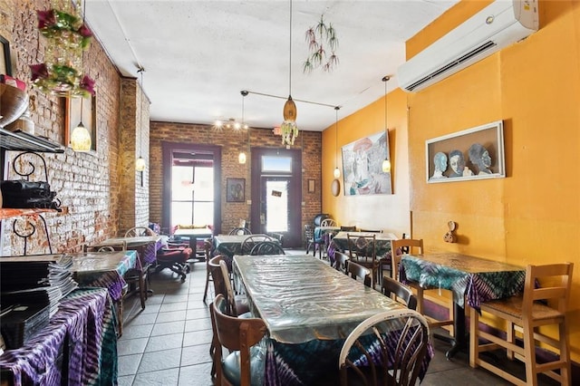 dining space with brick wall, a wall mounted air conditioner, and tile patterned floors