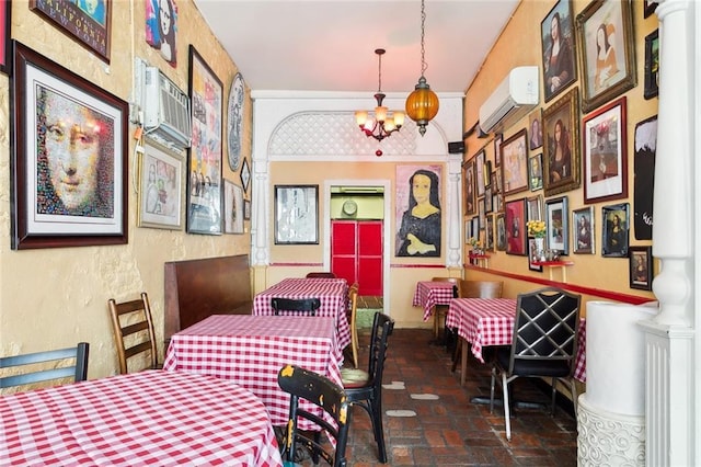 dining space featuring ornate columns, a wall mounted air conditioner, and an inviting chandelier