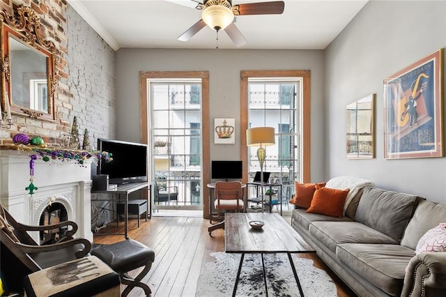 living room with hardwood / wood-style flooring, a wealth of natural light, a fireplace, and ceiling fan