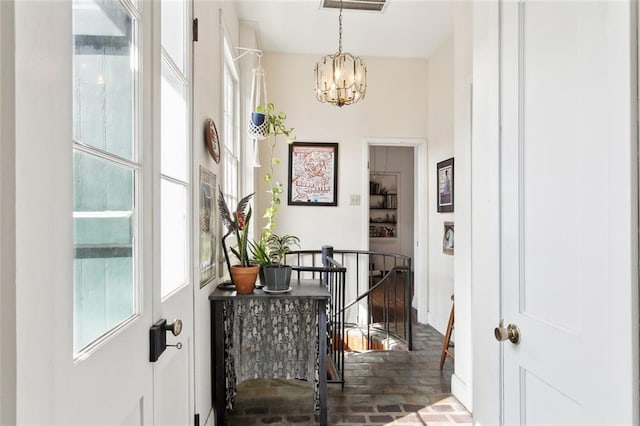 hallway with an inviting chandelier