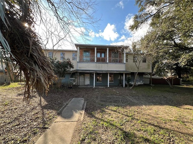 view of front of home with a front lawn and a balcony