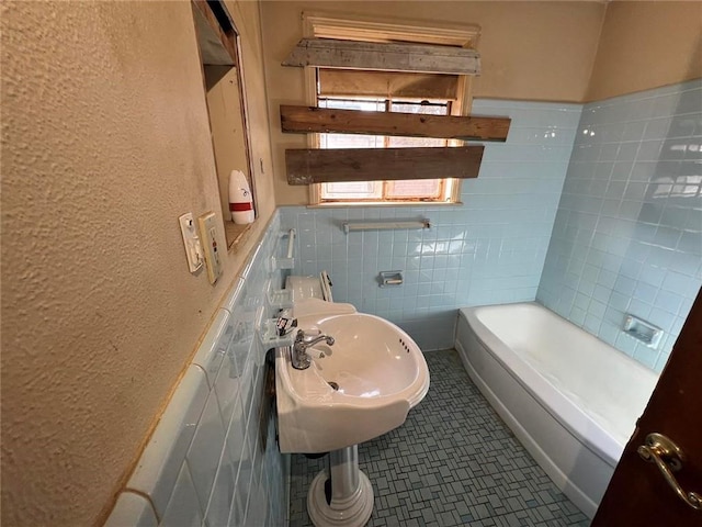 bathroom with tile walls, sink, tile patterned flooring, and a tub