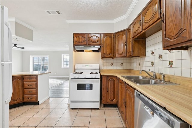 kitchen featuring sink, tasteful backsplash, light tile patterned floors, ornamental molding, and white appliances