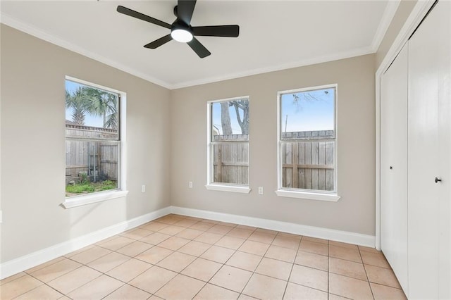 spare room with ornamental molding, ceiling fan, and light tile patterned flooring