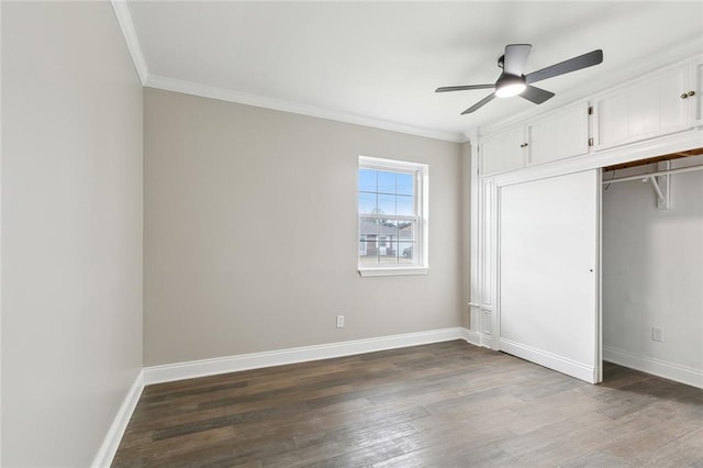 unfurnished bedroom with dark wood-type flooring, ceiling fan, ornamental molding, and a closet