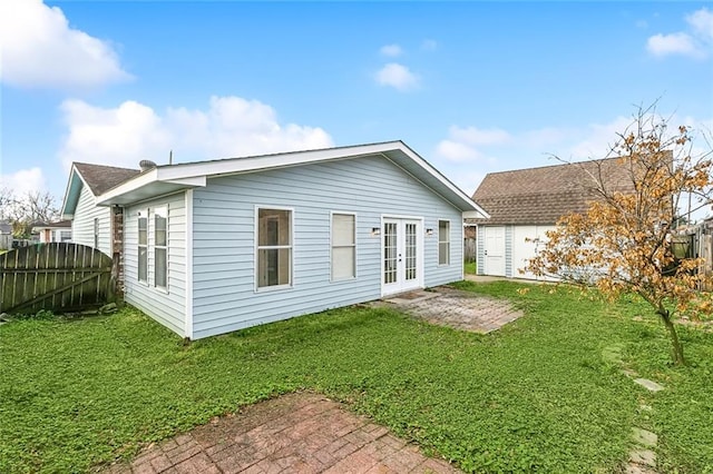 back of property featuring a lawn, a patio, and french doors