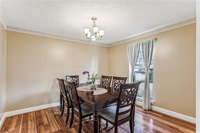 dining area with hardwood / wood-style flooring, a textured ceiling, and an inviting chandelier