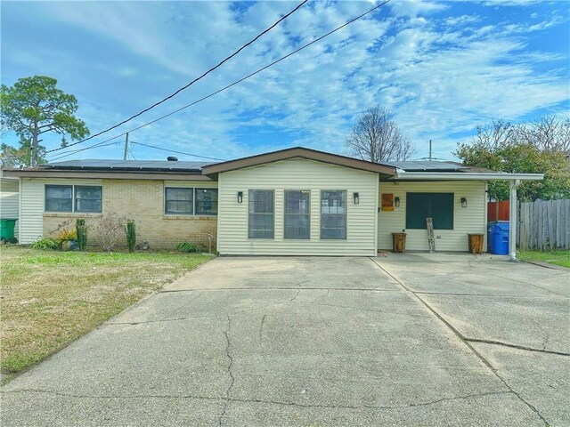 rear view of property with a yard and solar panels