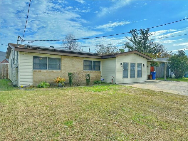 rear view of house featuring a carport and a lawn