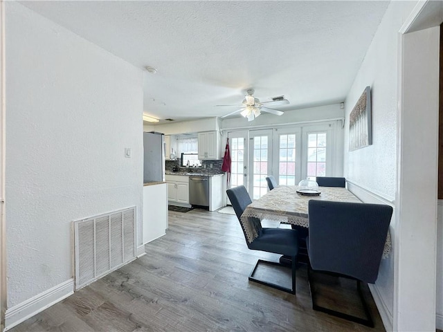 dining area featuring a textured ceiling, ceiling fan, and light hardwood / wood-style flooring