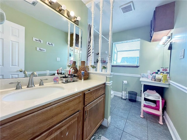 bathroom featuring tile patterned flooring, vanity, and toilet