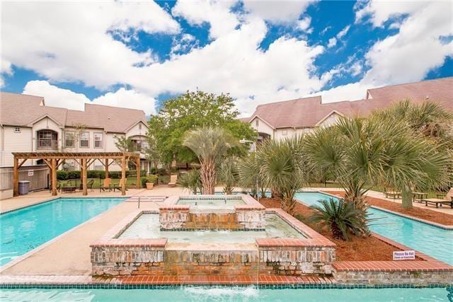 view of pool with pool water feature, a hot tub, a pergola, and a patio area