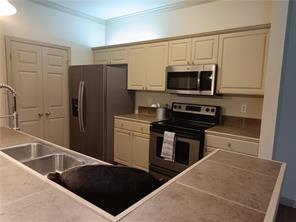 kitchen with cream cabinets, ornamental molding, and appliances with stainless steel finishes