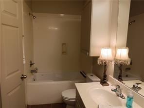 full bathroom featuring bathing tub / shower combination, vanity, and toilet