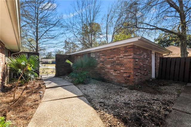 122 Belle Terre Blvd, Covington, LA 70433 - view of home's exterior with brick siding, a gate, and fence