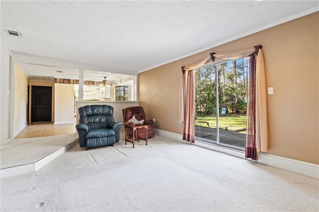 unfurnished room featuring light carpet, ceiling fan, ornamental molding, and a textured ceiling