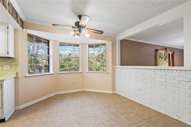 spare room featuring light tile patterned floors, plenty of natural light, and ornamental molding