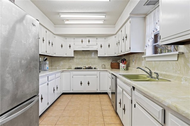 kitchen featuring sink, white cabinetry, light tile patterned floors, stainless steel appliances, and backsplash