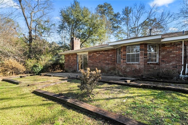 view of side of property with a patio area and a lawn