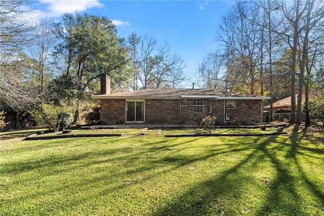 rear view of house featuring a yard