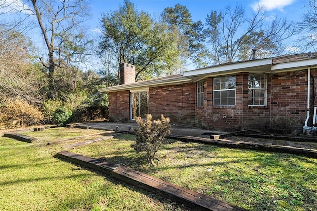 122 Belle Terre Blvd, Covington, LA 70433 - view of home's exterior featuring a chimney, a yard, brick siding, and a patio