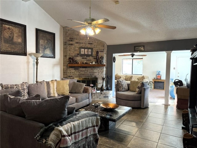 tiled living room with ceiling fan, decorative columns, a textured ceiling, a brick fireplace, and vaulted ceiling