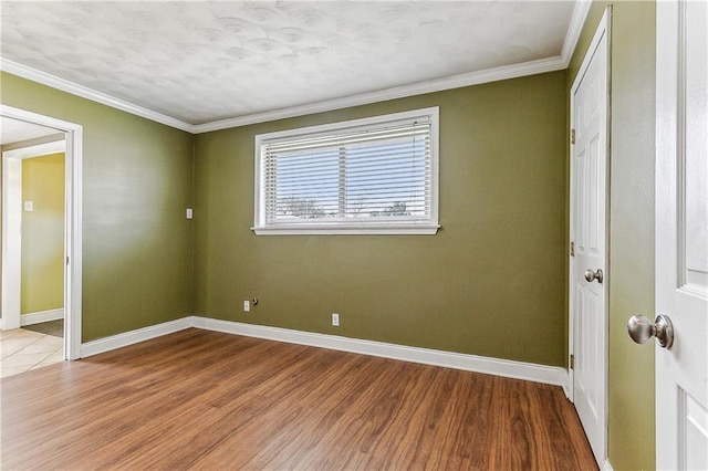 empty room with hardwood / wood-style floors and ornamental molding