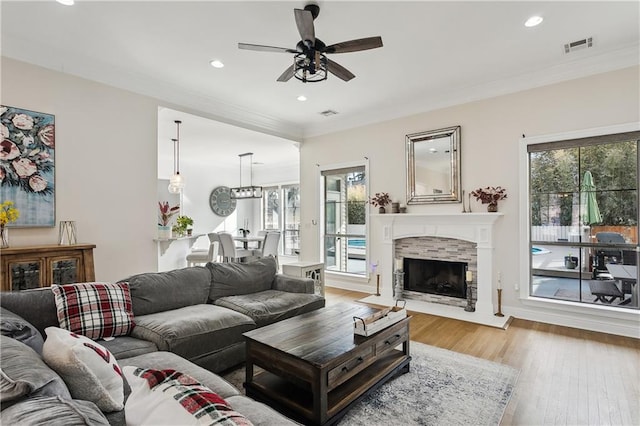 living room featuring crown molding, ceiling fan, and light hardwood / wood-style flooring