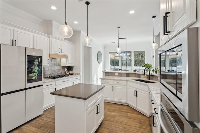 kitchen with sink, white cabinetry, hanging light fixtures, a kitchen island, and stainless steel appliances