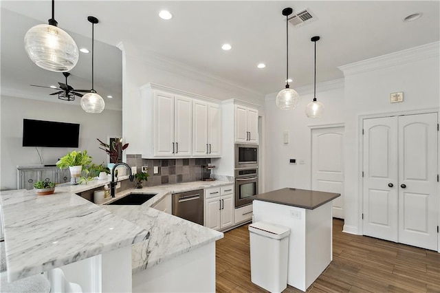 kitchen featuring stainless steel appliances, white cabinetry, sink, and light stone counters