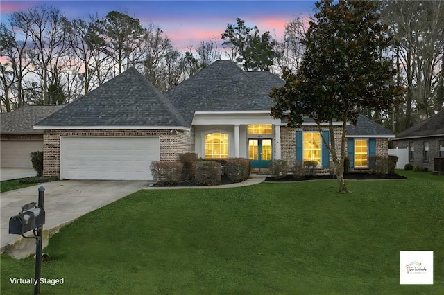 view of front of property featuring a yard, a garage, and central air condition unit