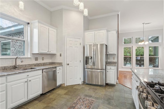 kitchen with sink, appliances with stainless steel finishes, a notable chandelier, white cabinets, and decorative light fixtures