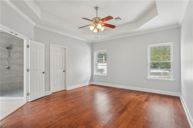 unfurnished bedroom featuring crown molding, a tray ceiling, wood-type flooring, and ceiling fan