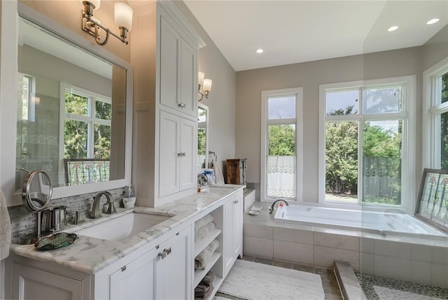 bathroom with vanity and a relaxing tiled tub