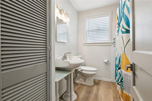 bathroom with hardwood / wood-style floors, sink, and toilet