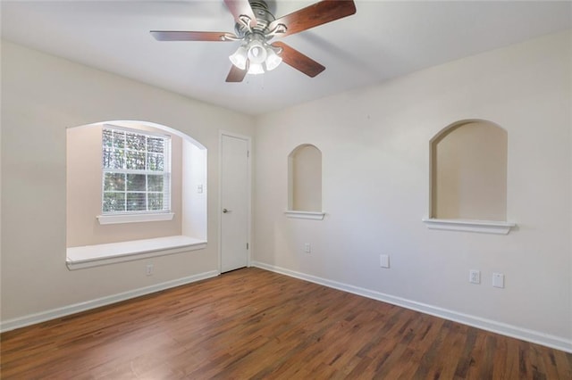 spare room with dark hardwood / wood-style floors and ceiling fan