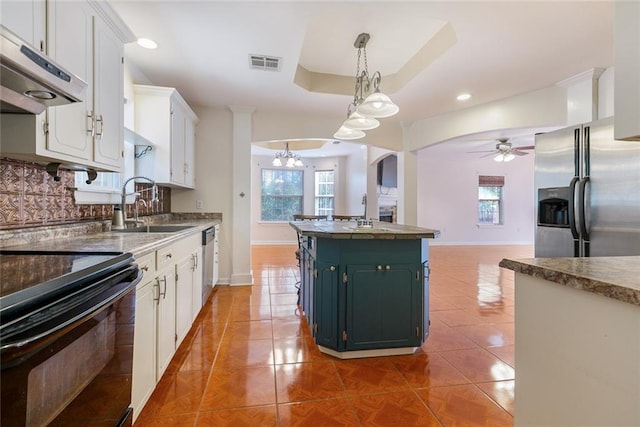 kitchen with tile patterned floors, white cabinetry, decorative light fixtures, appliances with stainless steel finishes, and a kitchen island