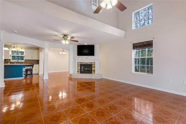 unfurnished living room featuring ceiling fan, sink, and tile patterned flooring