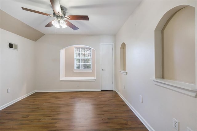 empty room with dark hardwood / wood-style flooring, lofted ceiling, and ceiling fan