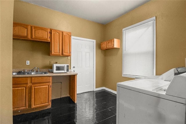 laundry area featuring cabinets, sink, and washer and dryer