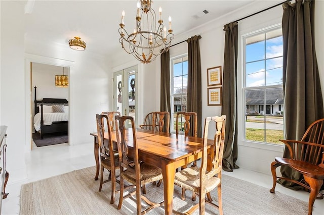 dining room featuring an inviting chandelier and french doors